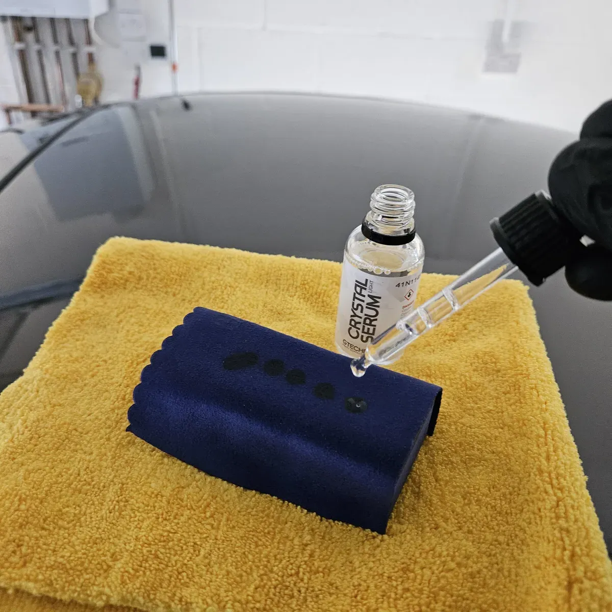 Ceramic coating being applied showing hydrophobic properties and gloss enhancement